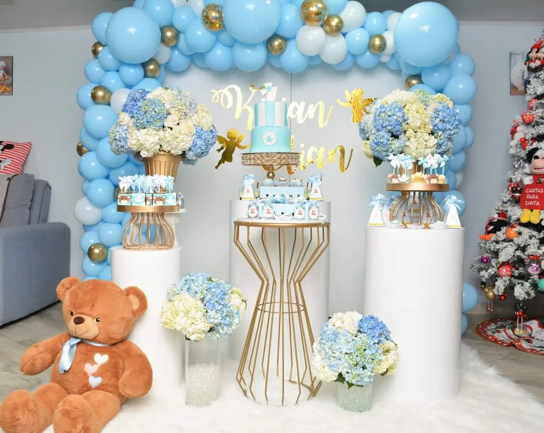 Montaje de baby shower en azul y dorado con globos, hortensias y oso de peluche